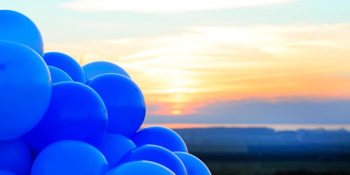 Bild på blå ballonger i solnedgång