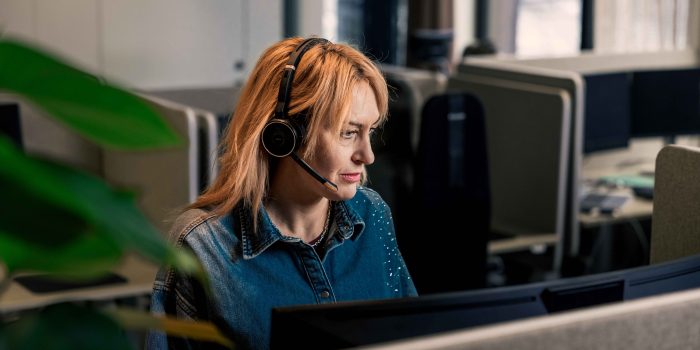Medarbetare i Kalmar Energis kundcenter som arbetar vid dator med headset.